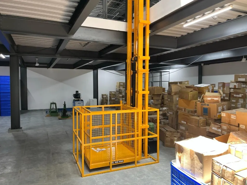 Steel mesh warehouse cage lift installed on an industrial site